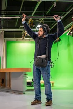 Boom microphone operator testing sound at TV studio. Stock Photos