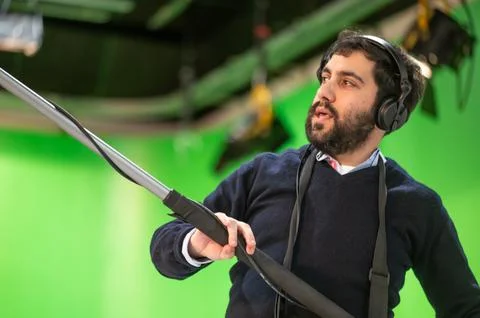 Boom microphone operator testing sound at TV studio. Stock Photos