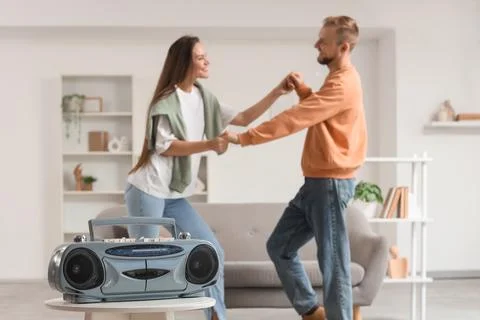 Boombox on table against young couple dancing at home, closeup Stock Photos