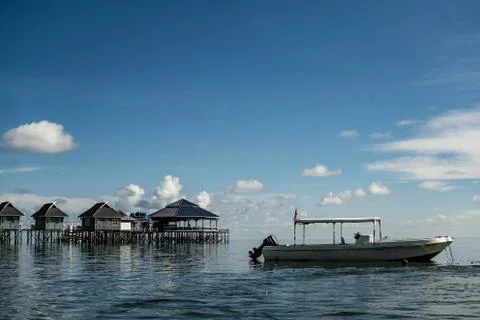 A boot and a chalet floating on the blue ocean Stock Photos