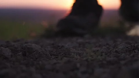 Boot close-up. A man climbs a mountain at sunset Stock Footage 169044428