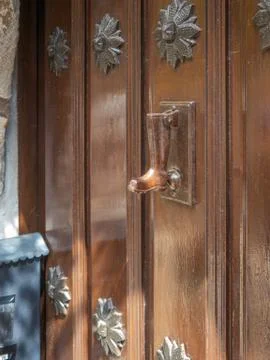 Boot-shaped knocker placed in an old rustic door Stock Photos