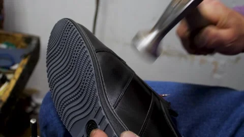 Bootmaker drive in nails in a shoe at the private workshop. Shoe making proce Stock Footage 279748900