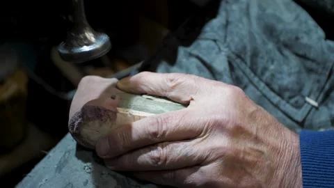 Bootmaker drive in nails in a shoe at the private workshop. Shoe making proce Stock Footage 279749429