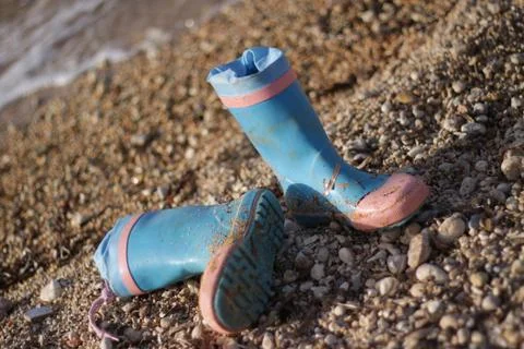 Boots left on beach Stock Photos