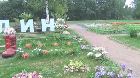 Boots in the park bench, flowers summer day Stock Footage 78648063