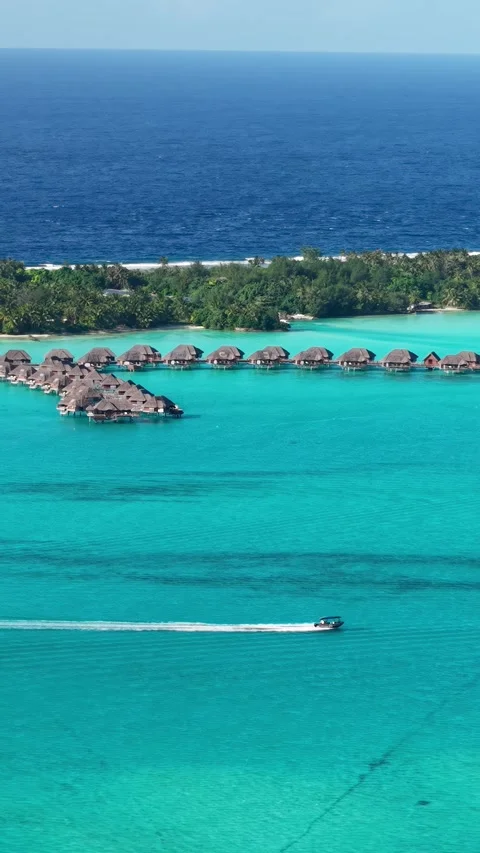 Bora Bora French Polynesia. Vertical Drone Shot of Overwater Villas, Boat in 스톡 동영상 348248287