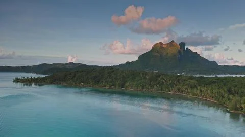 Bora Bora mount Otemanu reflecting in turquoise lagoon at sunset with lush Stock-Fotos