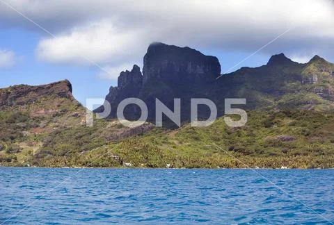 Bora Bora, Polynesia. Mountains, the sea, palm trees Stock Photos