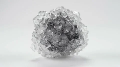 Borax crystal with dark center spins in infinite loop against light background Stock Footage 156048053