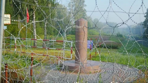 Border area with barbed wire and Poland marker monument early morning 動画素材 324026496