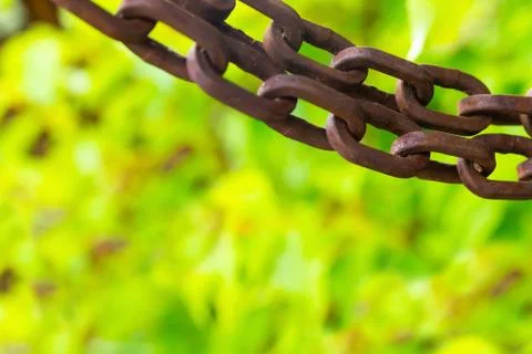 Border chain old rusty brown horizontal on green blurred flora background clo 스톡 사진