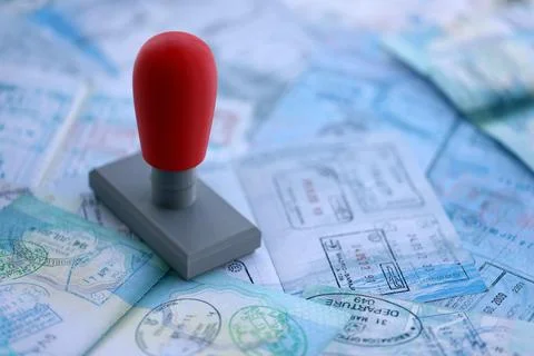 Border crossing stamp on big amount of passport pages full of colorful stamps Stock Photos