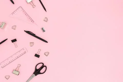 Border frame made of black office supplies on a  pink pastel background. Stock Photos