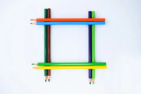 Border-frame made of eight different colored pencil crayons on a white backgr Stock Photos