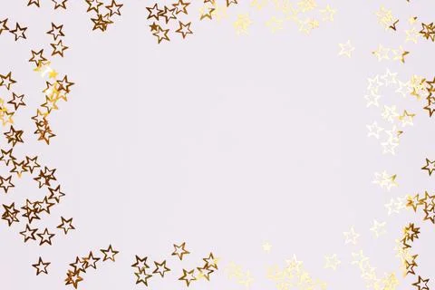 Border frame made of gold colored stars confetti. Stock Photos