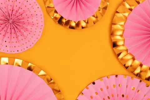 Border frame made of pink paper fans on a yellow background. Stock Photos
