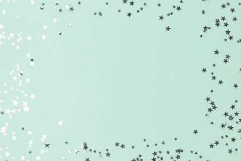Border frame made of silver colored stars confetti. Stock Photos