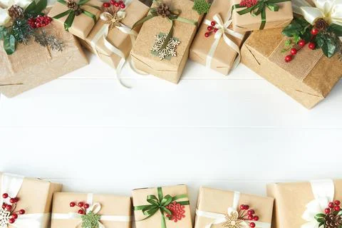 Border of gift boxes wrapped in kraft paper on white wood desk background Stock Photos