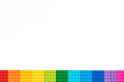 Border of Multicolor Plastick constructor bricks on white background. Popular Stock Photos