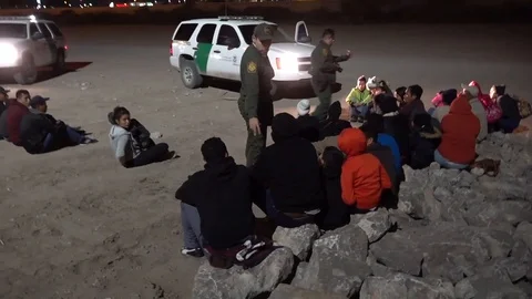 Border patrol agent counting migrants found at Mexican border at night Stock Footage 106117163