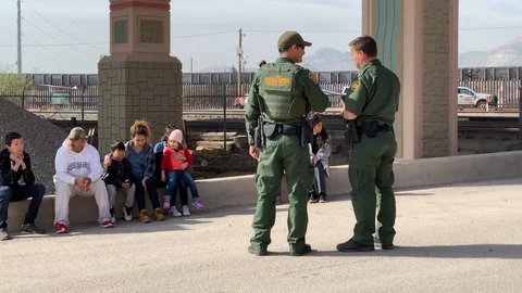 Border patrol agents with migrant family Vidéo 109171663