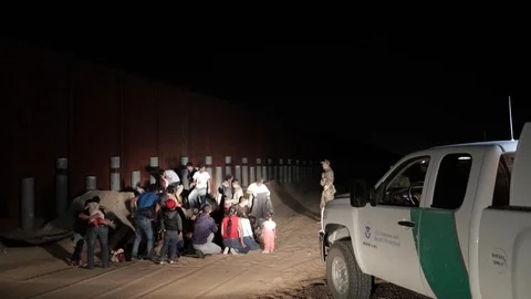 Border Patrol apprehend group of illegal immigrants at border wall Stock Footage 109537989