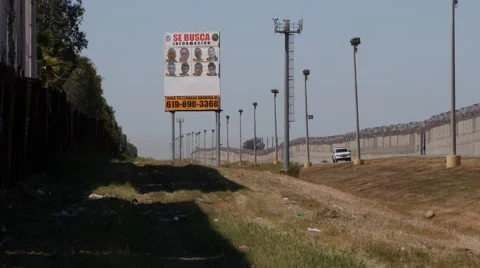 Border Patrol car sitting between fences with Wanted poster in the foreground Stock Footage 48607222
