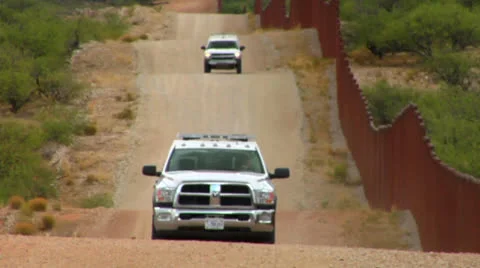 Border patrol vehicles move along the U.S. Mexico border. Stock Footage