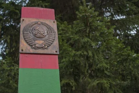 Border post green, red horizontal stripes, plate depicting  coat of arms of USSR Stock Photos