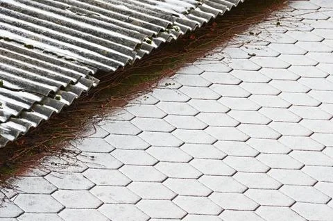 The border of two roofs with different coatings covered with fresh snow. Sele Stock Photos