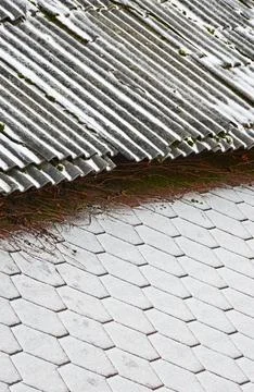 The border of two roofs with different coatings covered with fresh snow. Sele Stock Photos