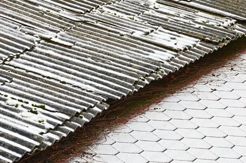 The border of two roofs with different coatings covered with fresh snow. Sele Stock Photos