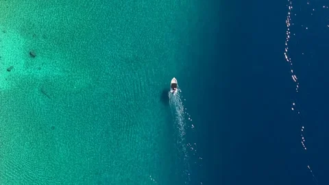 The border of two worlds: Drone footage of a white boat crossing the line Stock Footage 315293794