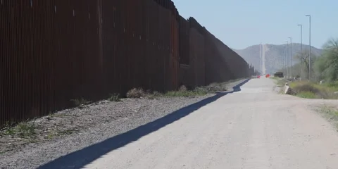 The Border Wall - looking west Lukeville, Arizona, fence and patrol road, 4k Stock Footage 240972175