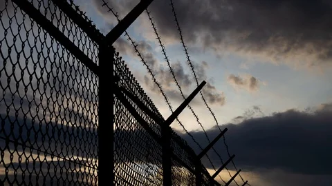Border Wall with Mesh Steel and Barbed Wire, Time Lapse at Sunrise Stock Footage 118517212