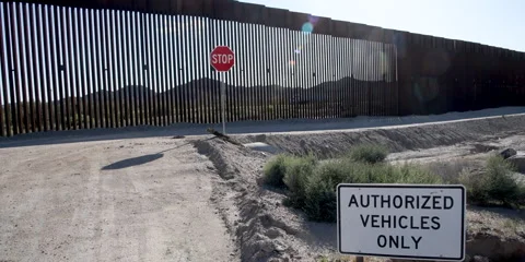 The Border Wall, restricted junction with border patrol road near Lukeville, AZ Stock Footage 240972698