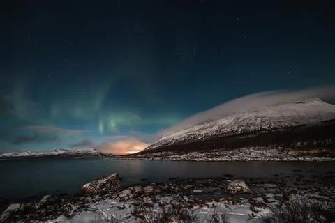 Borealis aurora sweeps over a large lake on a cloudless night in Kilpisjarvi, Stock Photos