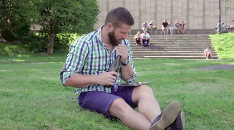 Bored and sleepy man browsing tablet yawns and drinks wine from bottle. Vidéo 67239462