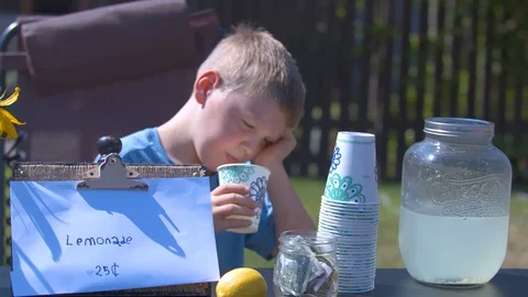 Bored Boy Drinking and Selling Lemonade Stock Footage 94397375