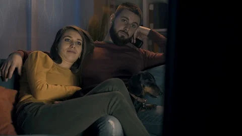 Bored couple watching TV on the sofa Stock Footage 128728161