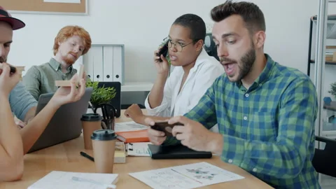 Bored employees busy with casual stuff during meeting at work playing games and Stock Footage
