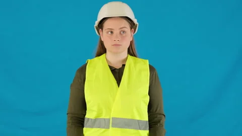 Bored engineer assistant in safety uniform at blue wall Stock Footage 316106818