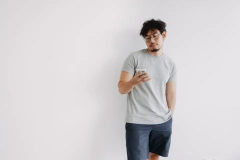 Bored face man using mobile phone app boringly isolated on white. Stock-Fotos