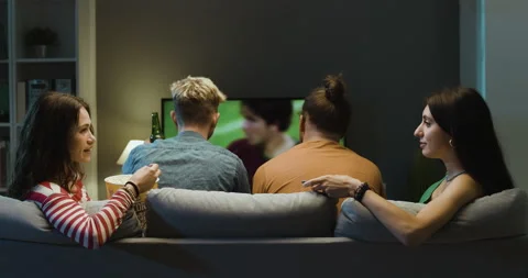 Bored girls talking together while boyfriends are watching soccer Stock Footage 297783343