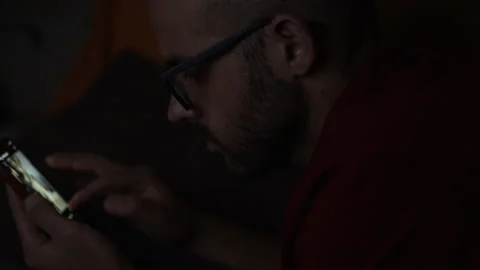 Bored Guy Lying In The Dark While Scrolling Feeds Through His Phone Stock Footage 152040058