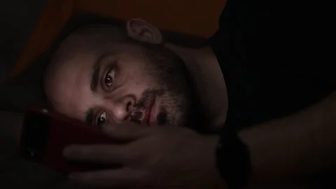 Bored Guy Lying On His Bed In The Dark While Scrolling Feeds Through His Phone Stock Footage 151824893