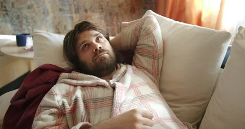 Bored, idle slacker man on couch, procrastinating and wasting time. Laziness Stock Footage 238426569