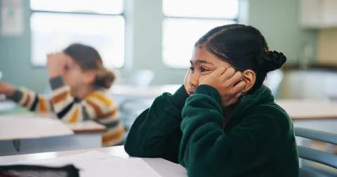 Bored, learning and child thinking in classroom for course, development and Stock Photos