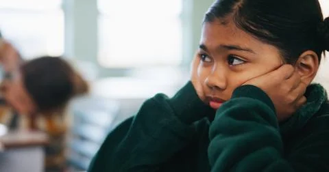 Bored, learning and kid thinking in classroom for course, development and Stock Photos